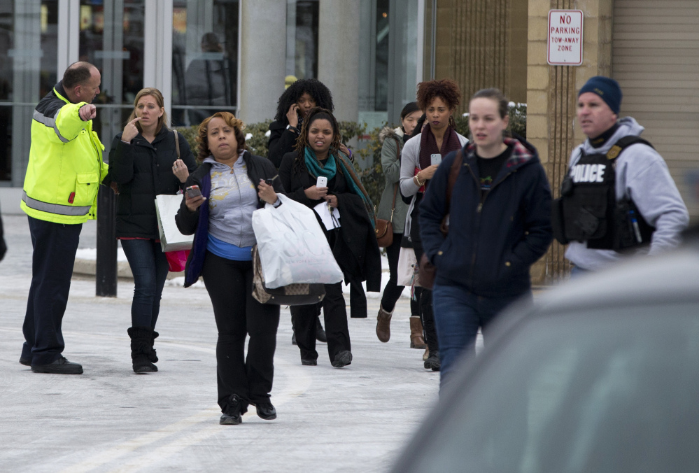 Police and law enforcement evacuate The Mall of Columbia after a shooting on Saturday in Columbia, Md. Police say three people died in a shooting at the mall in suburban Baltimore, including the presumed gunman.