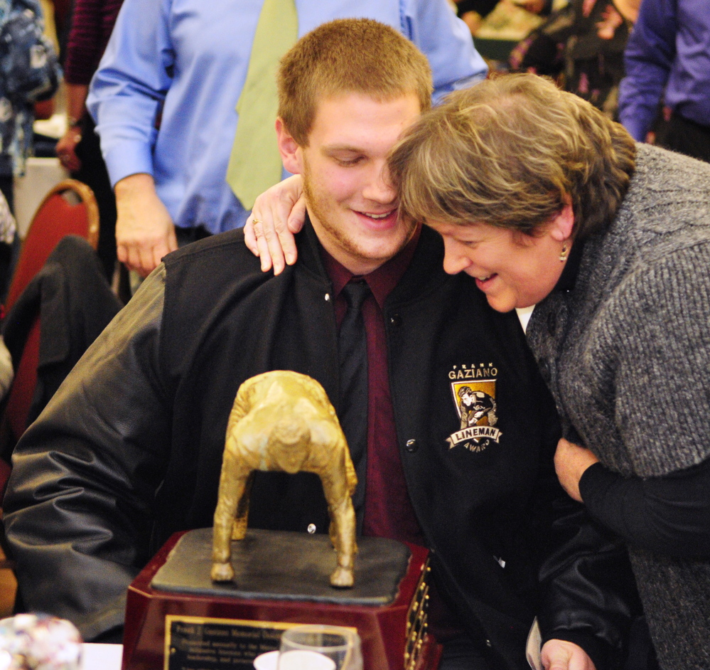 Staff photo by Joe Phelan Oak Hill defensive lineman Luke Washburn, left, gets a hug from his aunt Taffe Robbins after he won the Gaziano Lineman Award on Saturday January 25, 2014 in the Augusta Civic Center.