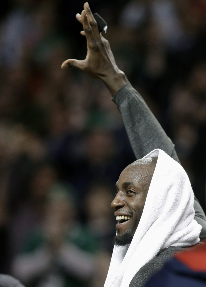 Brooklyn Nets forward Kevin Garnett, formerly of the Boston Celtics, waves to the crowd during a tribute to him in an NBA basketball game against the Boston Celtics, Sunday, Jan. 26, 2014, in Boston. (AP Photo/Steven Senne)