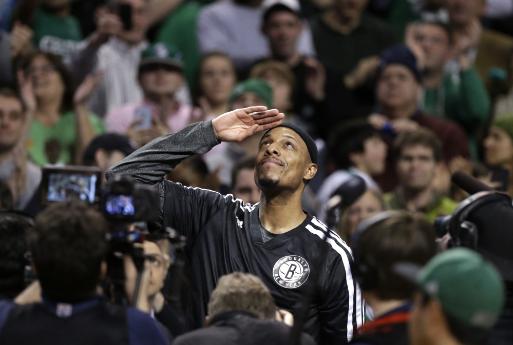 Brooklyn Nets forward Paul Pierce, center, formerly of the Boston Celtics, salutes the crowd during a tribute to him in the first half of an NBA basketball game against the Boston Celtics, Sunday, Jan. 26, 2014, in Boston. (AP Photo/Steven Senne)