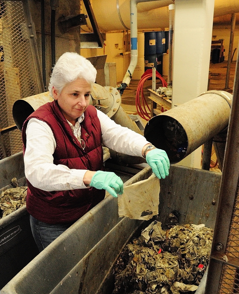 Uninvited pest: Jane Carroll, process and safety director, pulls an intact baby wipe that came out of a rag press after it was removed by the bar rack at the beginning of the water treatment process Friday at the waste water treatment plant on Jackson Avenue in Augusta.