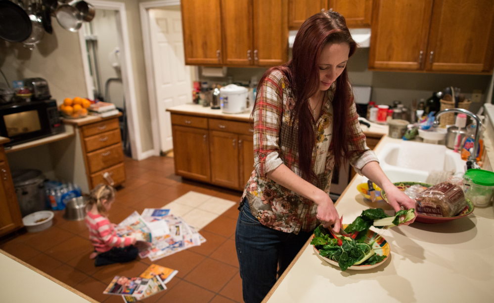 Maggie Barcellano prepares dinner at her father’s house in Austin, Texas, on Saturday. Barcellano, who lives with her father, enrolled in the food stamps program to help save up for paramedic training while she works as a home health aide and raises her 3-year-old daughter.