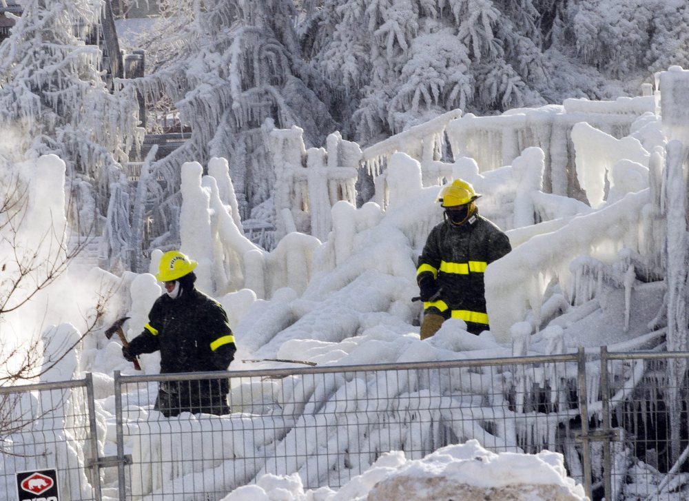 Rescue personnel search on Friday through the icy rubble of fire that destroyed a seniors’ residence in L’Isle-Verte, Quebec. The search was temporarily called off Sunday because of frigid temperatures.