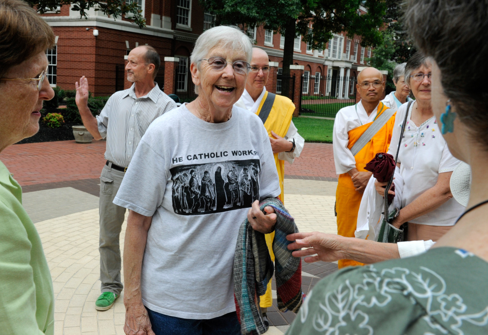 In this Aug. 9, 2012, file photo, Sister Megan Rice, center, and Michael Walli, in the background waving, are greeted by supporters as they arrive for a federal court appearance in Knoxville, Tenn.