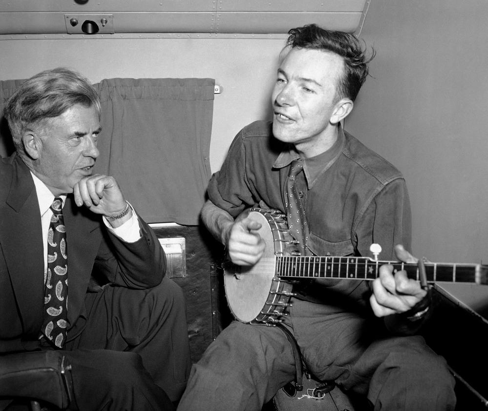 In this Aug. 28, 1948 file photo, Henry A. Wallace, Progressive Party presidential candidate, listens to Pete Seeger on a plane between Norfolk and Richmond, Va. Seeger died on Monday Jan. 27, 2014, at the age of 94.