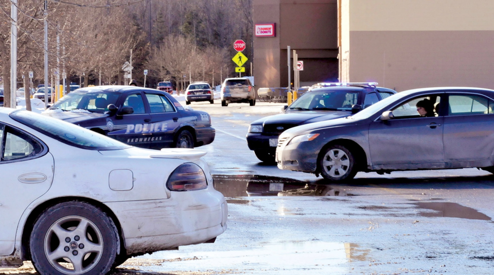 TEMPORARILY CLOSED: Shoppers in vehicles are blocked by police cruisers from entering the Walmart parking lot in Skowhegan as police search the building after a reported bomb threat on Tuesday.