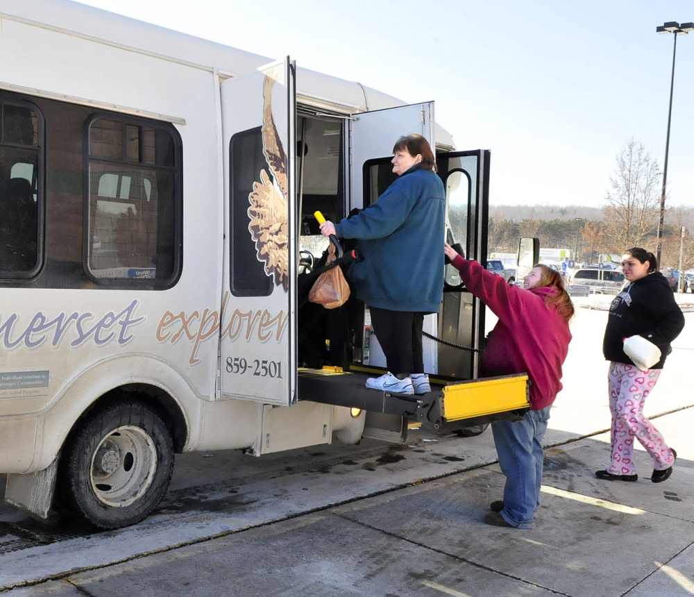 ALL ABOARD: Somerset Explorer bus driver Rhonda Watson, center, helps passengers to board the bus during a stop at Hannaford supermarket in Skowhegan.