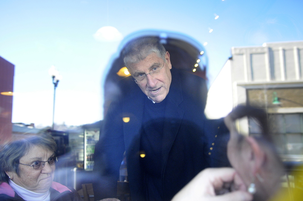 ON THE RUN: Viewed through the window of the Downtown Diner, on Water Street in Augusta, independent gubernatorial candidate Eliot Cutler speaks Wednesday with diners.