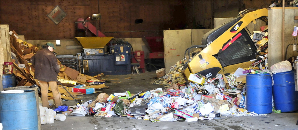 PACKING: Workers use machinery to pile paper inside the Sandy River Recycling Center in Farmington on Thursday. The center will close by June 30.