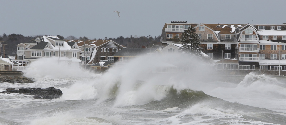 Large waves smash into a sea wall along the shore in Kennebunk last March. Some areas in York and Cumberland counties would be re-designated as at high risk for flooding under new federal flood maps.