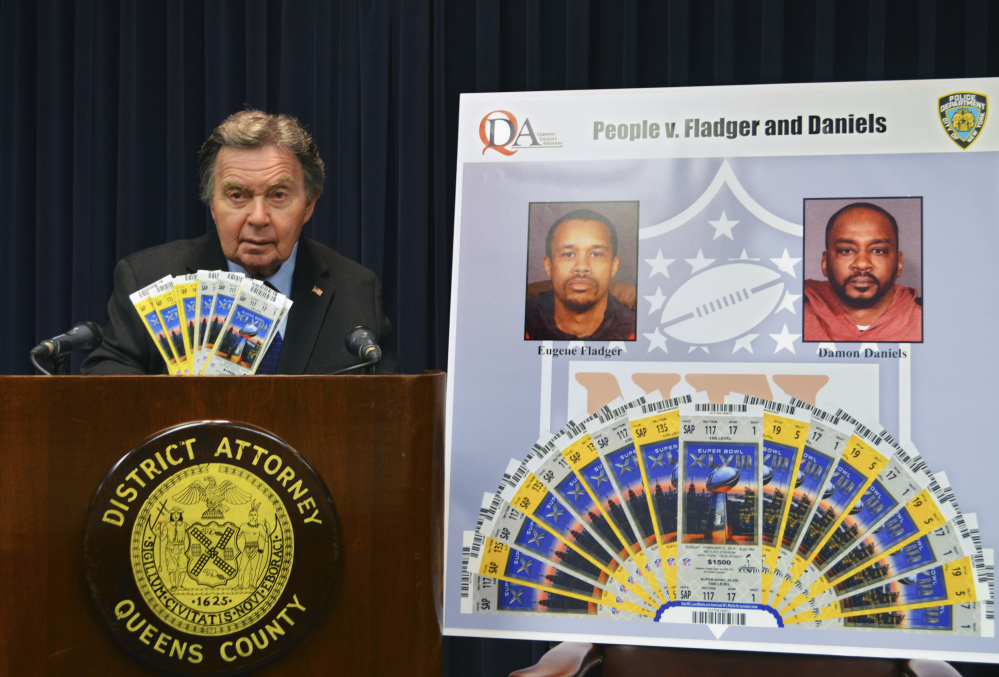 Richard Brown, Queens County district attorney, displays counterfeit Super Bowl tickets at a news conference Tuesday in New York. Two men made high-quality counterfeit tickets for the Super Bowl and other postseason NFL games and sold them online, authorities said. The men face charges of forgery, possession of forged instruments and other trademark counterfeit charges.