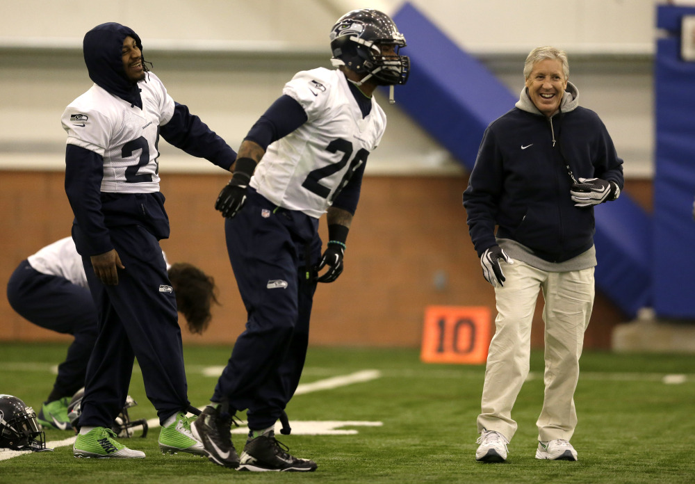 ON THE MOVE: Seattle Seahawks head coach Pete Carroll, right, laughs as running back Marshawn Lynch, left, and fullback Michael Robinson, center, warm up at the start of practice Thursday in East Rutherford, N.J. Carroll and general manager John Schneider have made 839 roster moves during their time in Seattle. The Seahawks and the Denver Broncos are scheduled to play in the Super Bowl XLVIII on Sunday.