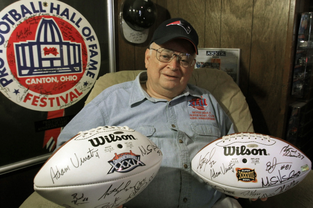 Don Crisman of Kennebunk holds up a few of the footballs he has collected over 44 years of attending all the Super Bowl football games. Crisman is a charter member of the Never Miss a Super Bowl club.