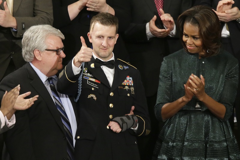 Army Ranger Sgt.1st Class Cory Remsburg acknowledges applause from first lady Michelle Obama and others during President Barack Obama's State of the Union address on Capitol Hill in Washington, Tuesday Jan. 28, 2014.