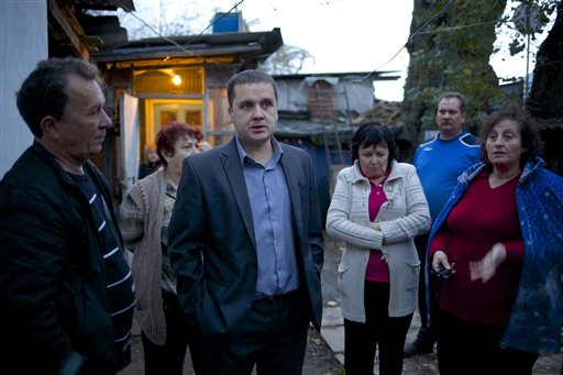 Igor Zarytovsky, center, and his father Vladimir, left, gather with their neighbors in the yard of the railroad house in the village of Vesyoloye outside Sochi, Russia. Unusual for Russia, Sochi area residents are not only willing to talk to reporters but stop them in the street and invite them over to see "what the real Sochi looks like."