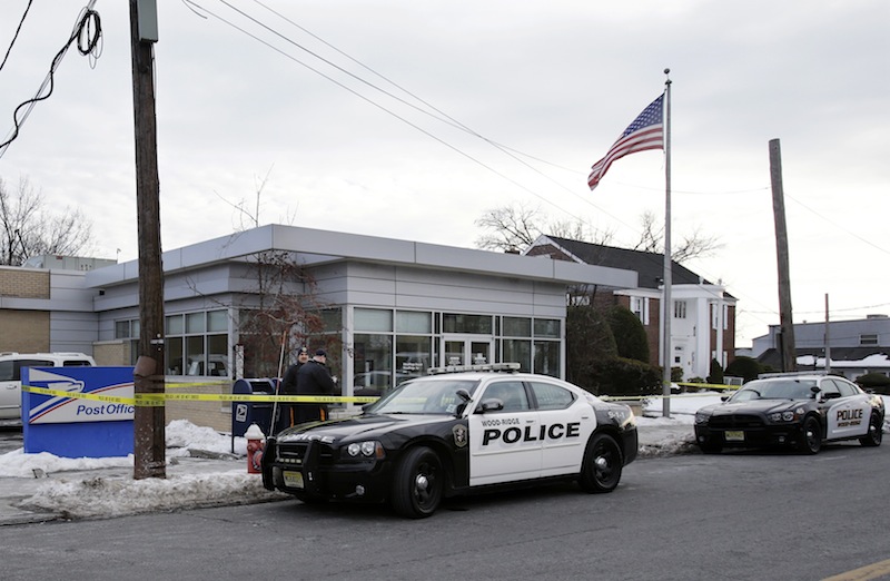 Police officers stand guard outside the closed post office in Wood-Ridge, N.J., Friday, Jan. 31, 2014. The FBI says a powder mailed to several locations in New York and New Jersey, including at least five hotels near the site of Sunday's Super Bowl appears not to be dangerous.