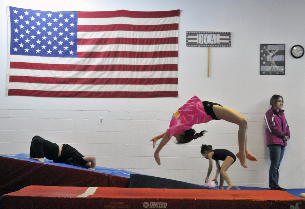 Glad to be back: Abby Drummond, 10, performs a back flip as she practices her vault routine at Decal Gymnastics in Farmington on Saturday. Decal re-opened today after closing because of flooding.