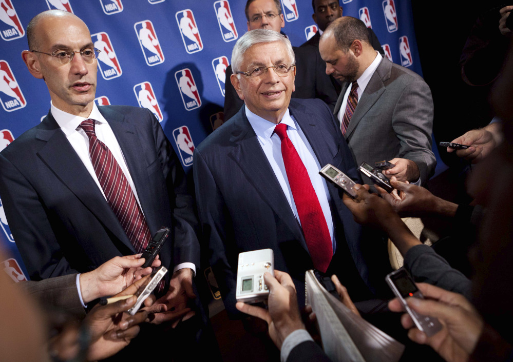 David Stern, center, speaks to the news media alongside Adam Silver in this November 2011 photo. Silver takes over as NBA commissioner from Stern, who retired after 30 years in his position.