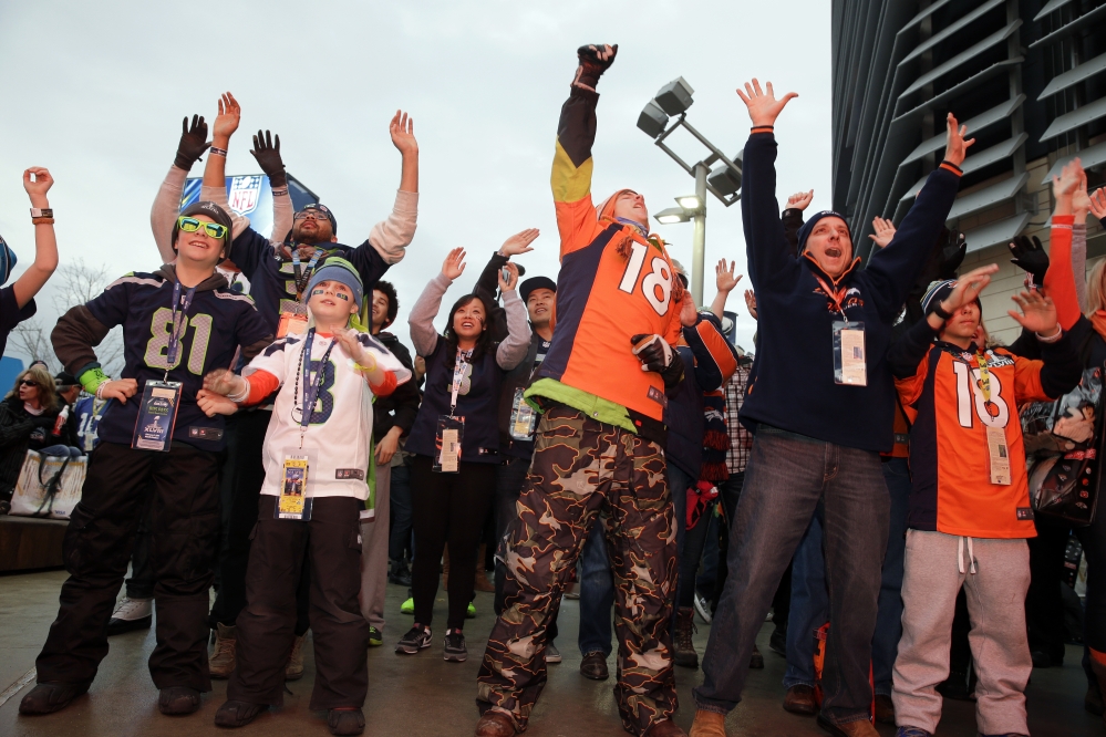 Fans play an interactive video game outside MetLife Stadium before the NFL Super Bowl XLVIII football game between the Seattle Seahawks and the Denver Broncos Sunday.