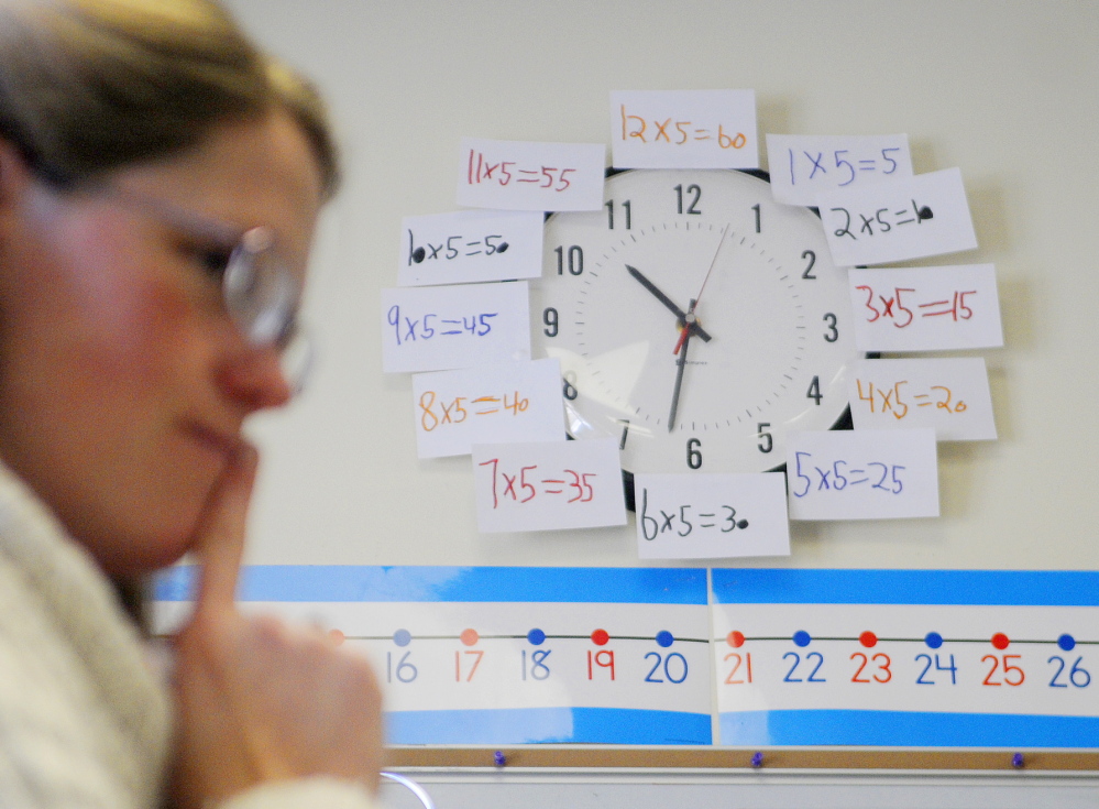 TALKING NUMBERS: The clock behind Readfield Elementary School third grade teacher Abby Shink is adorned with equations as she listens Wednesday to her class work through an equation with a “number talk,” an instructional activity RSU 38 uses to get students to discuss and critique arguments in math, as required in the Common Core State Standards.