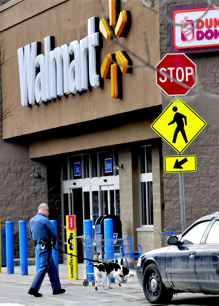 CRIME SCENE: A Maine State Police trooper and police dog enter the front of the Walmart store in Skowhegan on Monday, Feb. 3, 2014, after a bomb threat was reported less than a week after an earlier one. Employees and customers were not allowed in the store as police searched the building.