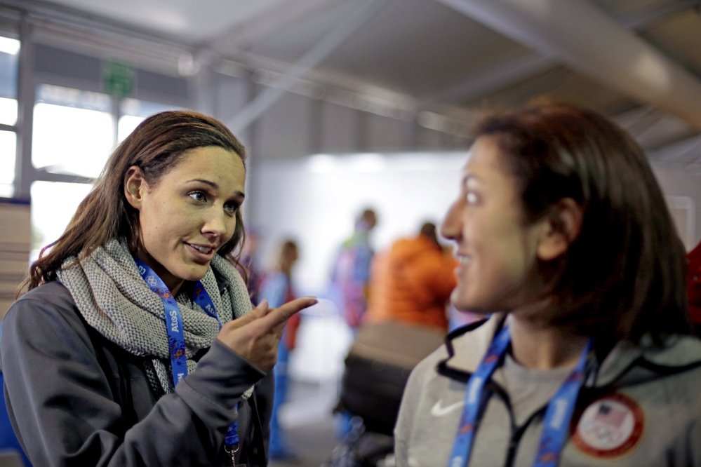 U.S. bobsled brakeman Lolo Jones, left, gestures to teammate, pilot Elana Meyers, during a television interview as the pair arrive at the 2014 Winter Olympics recently in Sochi, Russia.