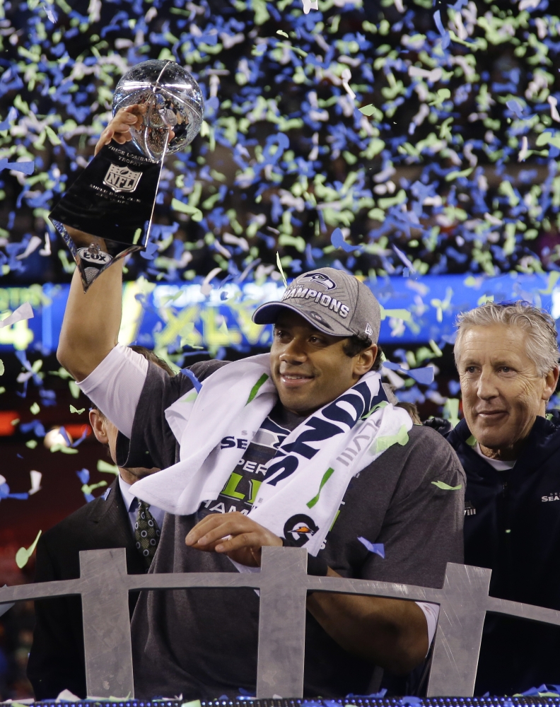 CHAMPIONS: Seattle quarterback Russell Wilson holds the Vince Lombardi Trophy as coach Pete Carroll looks on after the Seahawks defeated the Denver Broncos 43-8 in Super Bowl XLVIII on Sunday in East Rutherford, N.J.