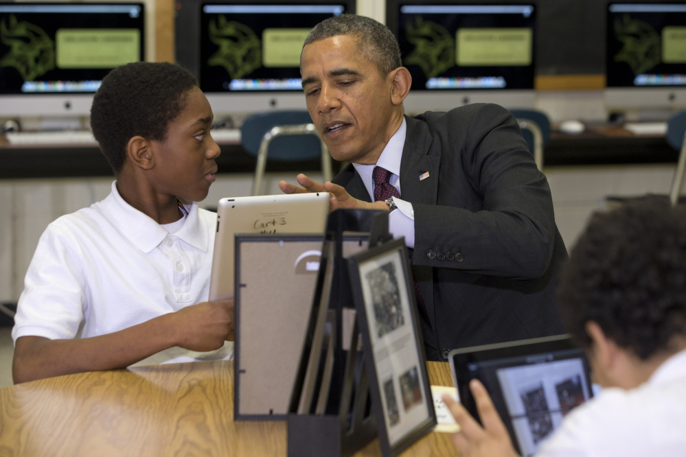President Barack Obama looks at a student’s iPad project Tuesday at Buck Lodge Middle School in Adelphi, Md., where he spoke about his goal of connecting 99 percent of students to next-generation broadband and wireless technology within five years.