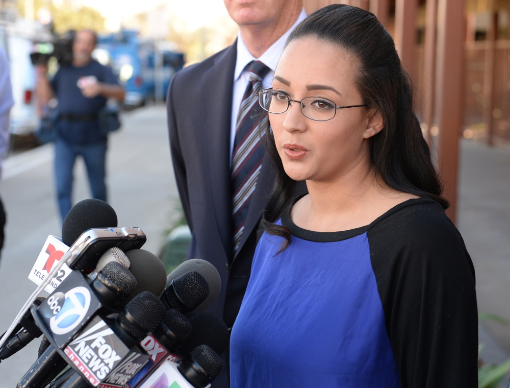 In this Jan. 20, 2014, photo, a woman who wanted to be identified by her first name, Jamie, speaks at a news conference in front of Alhambra High School in Alhambra, Calif., where Andrea Cardosa, not seen, last worked as vice principal of student services. Cardosa, who was confronted by Jamie on a YouTube video, was charged Monday with 16 counts of sexual abuse, prosecutors said.