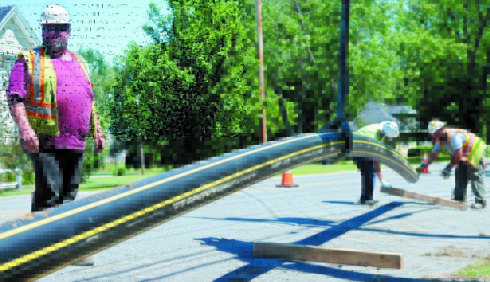 GROWING WITH THE FLOW: Dan McGee, of McGee Construction, helps move a natural gas pipeline last summer during the company’s installation of a distribution line through Kennebec County for Summit Natural Gas of Maine.
