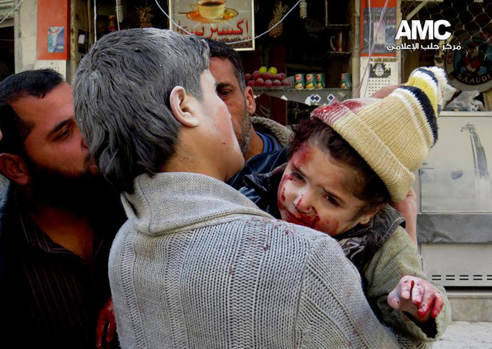 This photo provided by the anti-government activist group Aleppo Media Center (AMC), which has been authenticated based on its contents and other AP reporting, shows a Syrian man carrying a wounded child following a Syrian government airstrike in Aleppo, Syria, Monday.