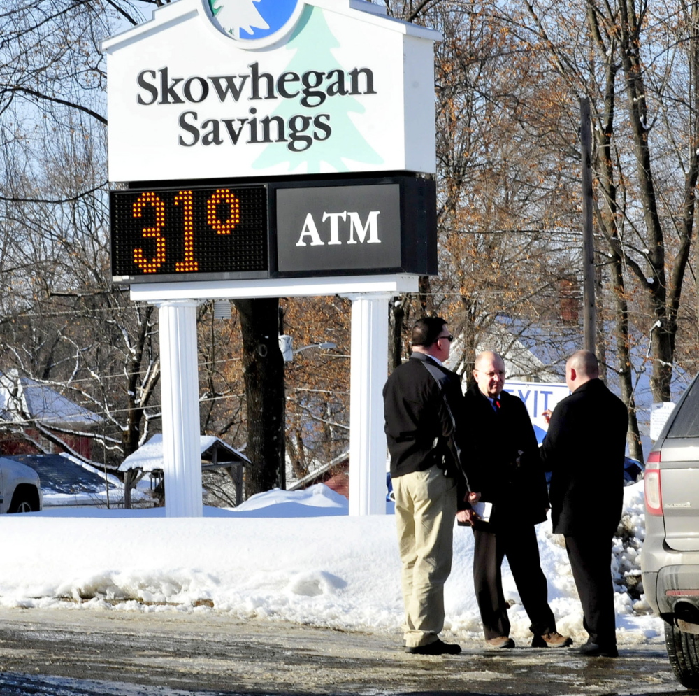 ROBBERY: Police, including Somerset County Chief Deputy Dale Lancaster, center, consult outside the Skowhegan Savings bank branch in Bingham after it was robbed Tuesday.