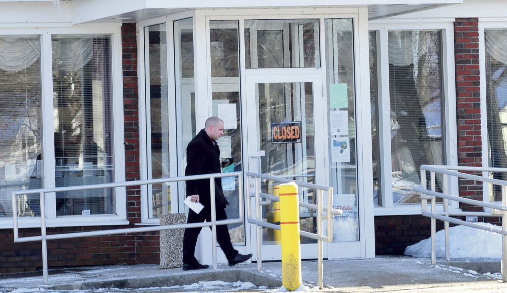 CLOSED: A police detective enters the closed Skowhegan Savings bank branch in Bingham after it was robbed Tuesday.
