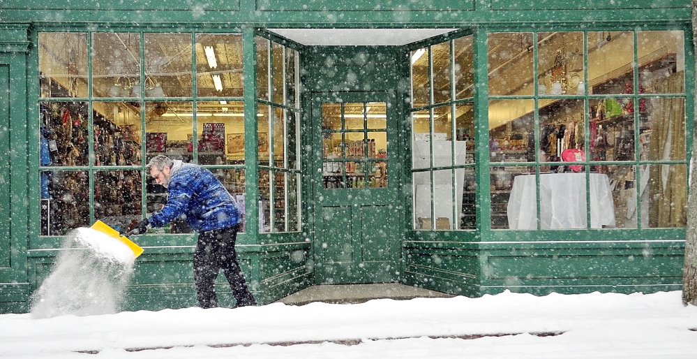 As more snow continues to fall, store manager Dennis Trimpop shovels on Wednesday in front of Reny’s Department Store on Water Street in Gardiner.