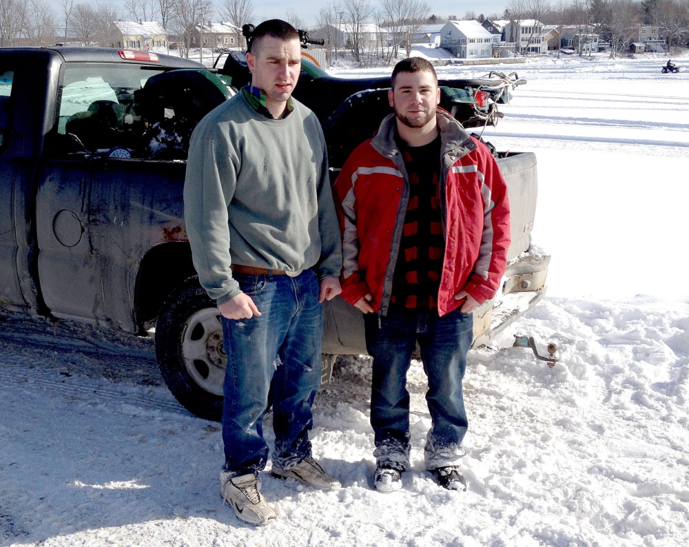 survivors: Donald Cowles, left, and Lucas Cole stand beside an all-terrain vehicle that went through the ice on China Lake on Thursday. Cowles helped Cole get out of the water.