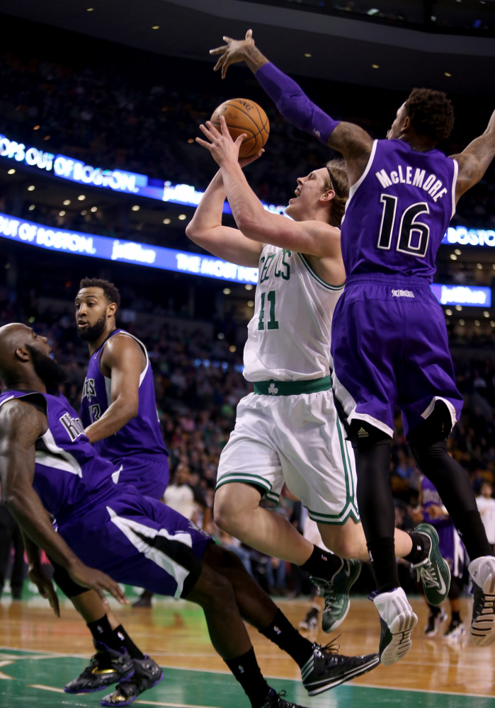 Boston Celtics center Kelly Olynyk (41) drives to the basket against Sacramento Kings shooting guard Ben McLemore (16) and Quincy Acy on Friday in Boston.