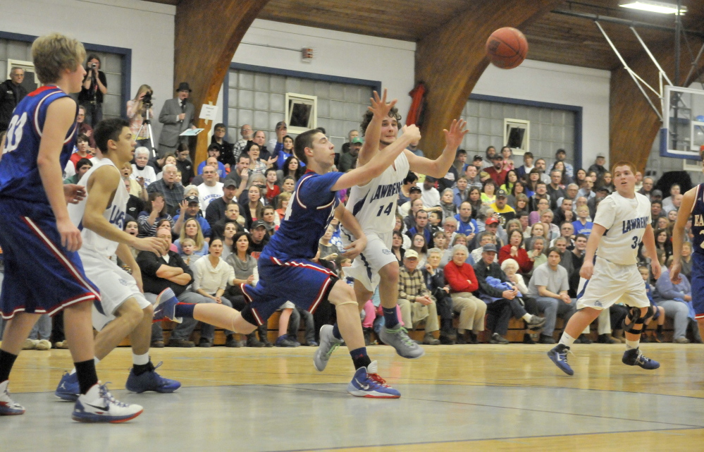 Staff photo by Michael G. Seamans Messalonskee High School's Nick Mayo, 24, left, battles for the loose ball with Lawrence High School's Brandon Hallee, 14, right, at Lawrence High School in Fairfield on Friday.