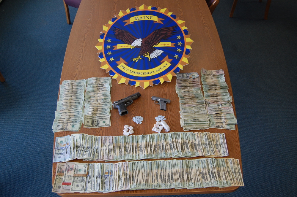 Police seized heroin, oxycodone and cash and guns in searches of houses in Bangor and Dedham.