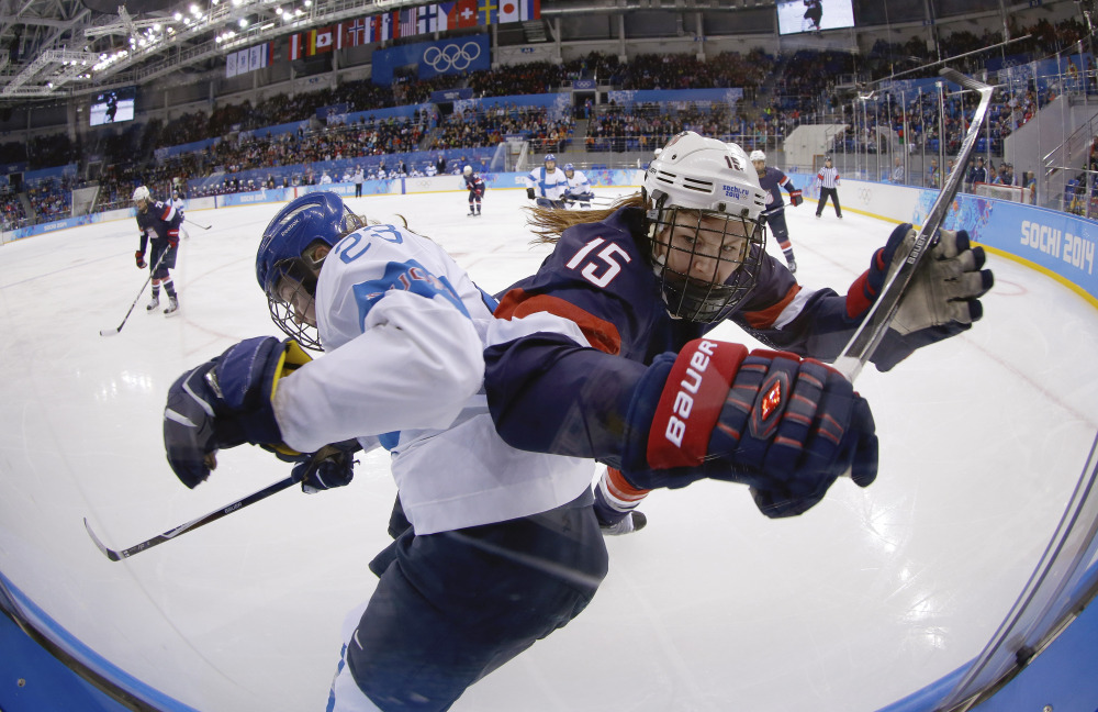 Nina Tikkinen of Finland and Anne Schleper of the United States battle for control of the puck against the glass during the second period of the women’s hockey game at the Shayba Arena.