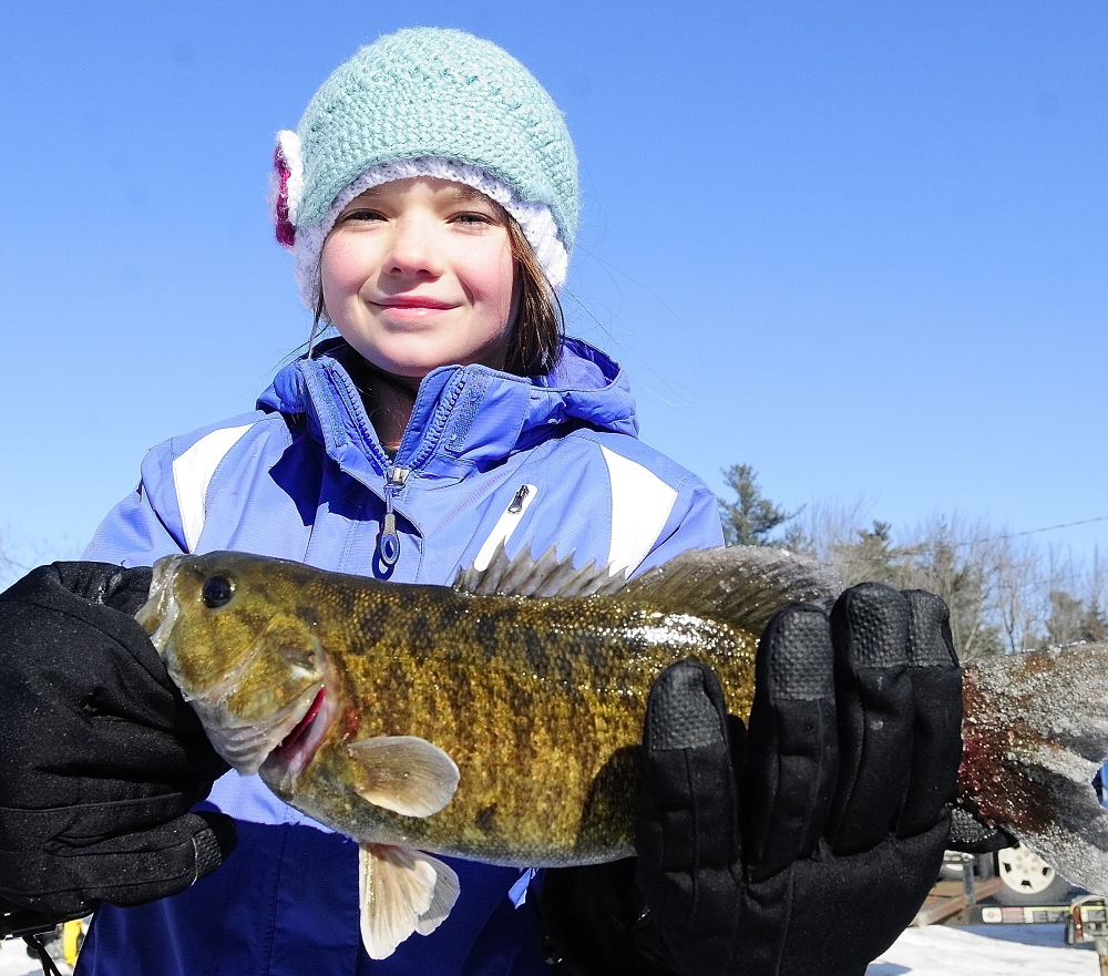 Small girl, big fish: Kathleen Mears, 9, of Brunswick, holds up a 2.19-pound bass she caught Saturday during an RSU 2 fundraiser ice fishing tournament at Cochnewagen Lake Town Landing in Monmouth.