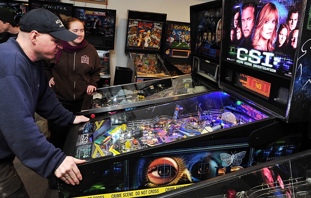 Theresa Nessel of Portland watches as her opponent, Jerry Lindsay of Oakland, racks up the points on CSI, a popular game for the tournament at the Maine State Pinball Championship in Gorham. Saturday, February 8, 2014. Gordon Chibroski, Staff Photographer