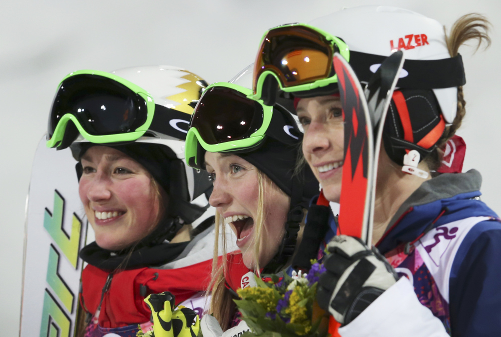 Canada’s Justine Dufour-Lapointe, center, celebrates her gold medal in the women’s moguls final, with her sister and silver medalist Chloe Dufour-Lapointe, left, and bronze medalist United States’ Hannah Kearney, at the Rosa Khutor Extreme Park, at the 2014 Winter Olympics, Saturday, in Krasnaya Polyana, Russia.