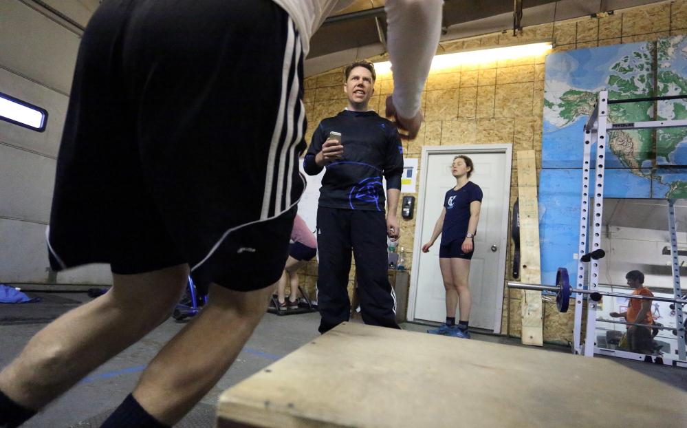 Will Sweetser, director of competitive programs at the Maine Winter Sports Center, leads athletes through a workout recently in a gym in Caribou. The center also has competition sites in Fort Kent and Presque Isle.