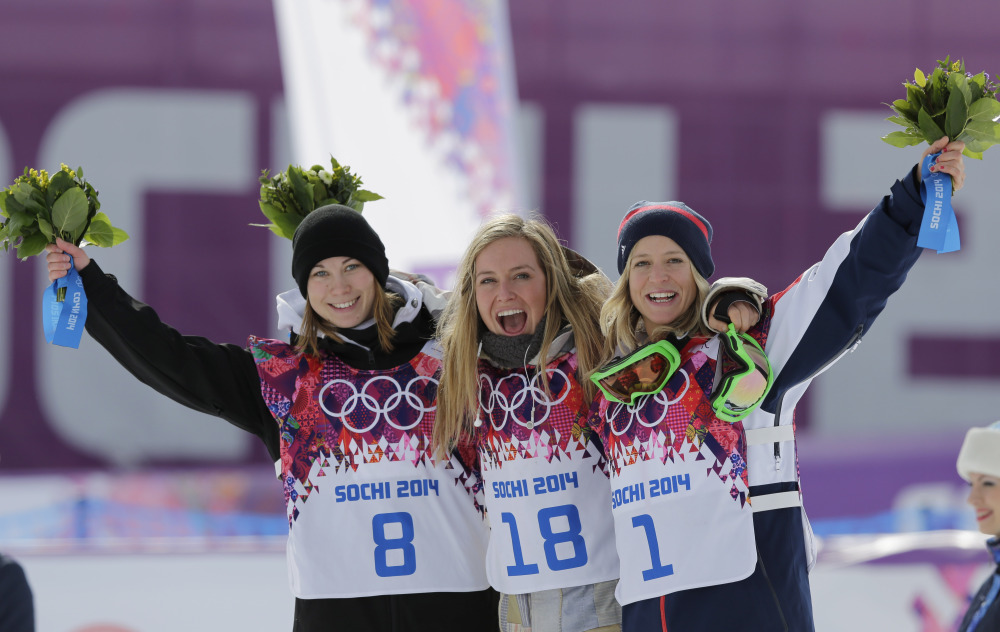 Jamie Anderson of the United States, center, celebrates with silver medalist Enni Rukajarvi of Finland, left, and bronze medalist Jenny Jones of Britain, after Anderson won the women’s snowboard slopestyle final at the 2014 Winter Olympics on Sunday.