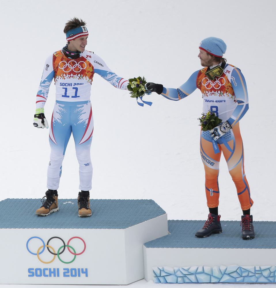 Austria's Matthias Mayer, left, and Italy's Christof Innerhofer celebrate during the flower ceremony after finishing the men's downhill event at the 2014 Winter Olympics on Sunday in Krasnaya Polyana, Russia.