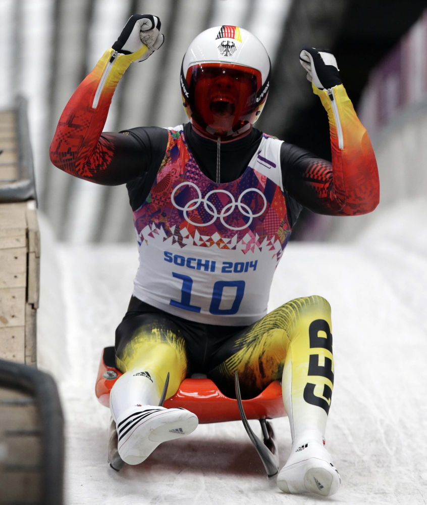 Felix Loch of Germany celebrates as he crosses the finish area to win the gold medal during the men’s singles luge final Sunday at the 2014 Winter Olympics in Krasnaya Polyana, Russia.