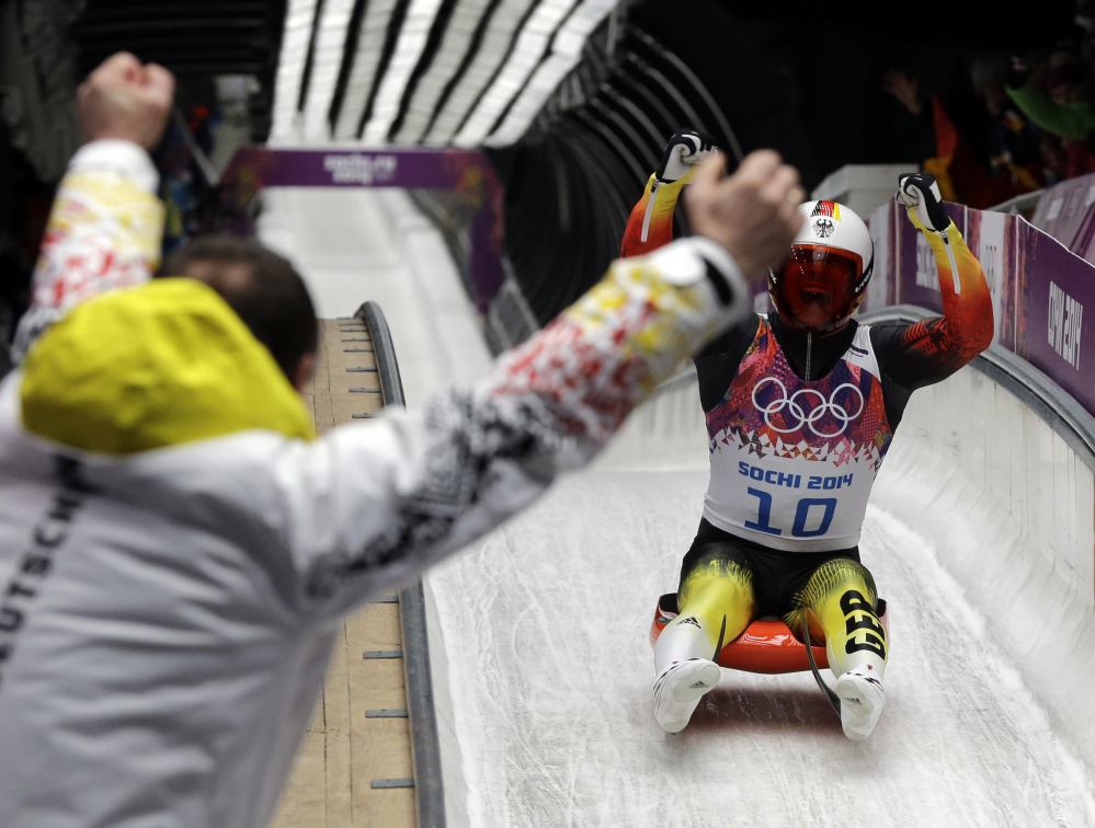 Felix Loch of Germany celebrates as he crosses the finish area to win the gold medal Sunday during the men’s singles luge final at the 2014 Winter Olympics in Krasnaya Polyana, Russia.