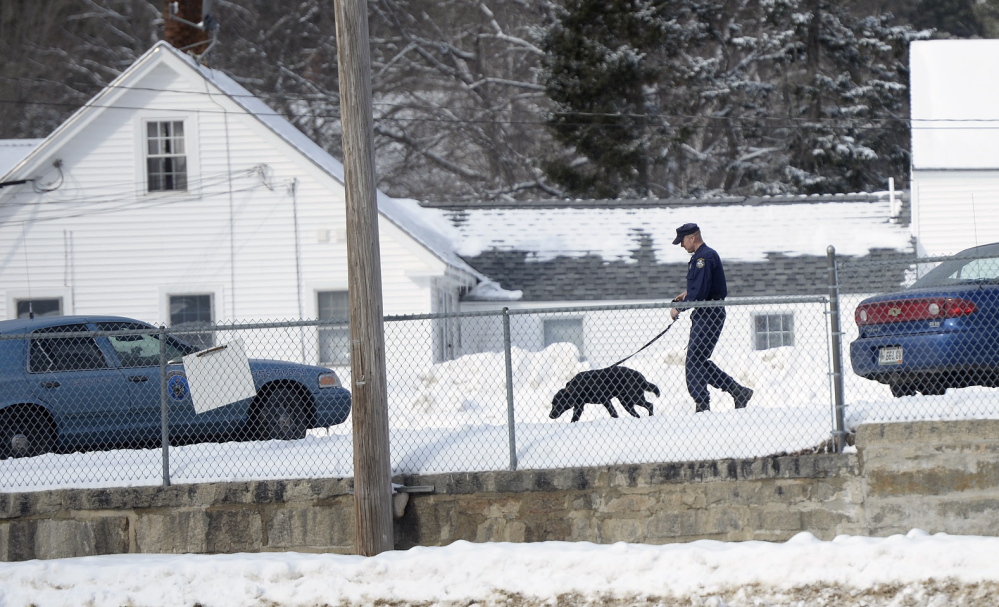A Maine State Police trooper with a police dog makes his way across the parking lot of the York County Courthouse in Alfred on Monday. Court was canceled for the day after a bomb threat.