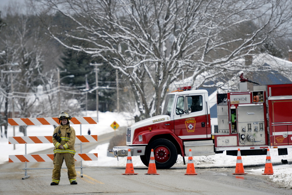 Alfred firefighter and EMT Anna Allard directs traffic away from the York County Courthouse in Alfred on Monday morning after a bomb threat was received.