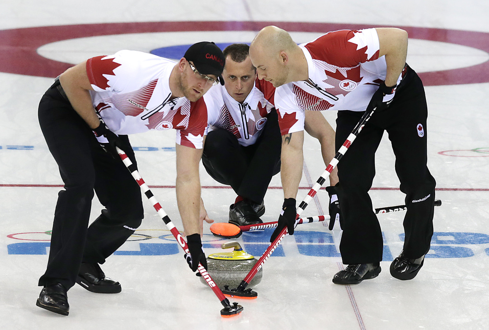 NOT SO FAST START: Canada’s E.J. Harnden watches the rock as Ryan Harnden, left, and Ryan Fry sweep the ice against Germany Monday, Feb. 10, in Sochi, Russia. The Canadians’ campaign has begun in underwhelming fashion after entering the men’s curling competition as gold-medal favorites.
